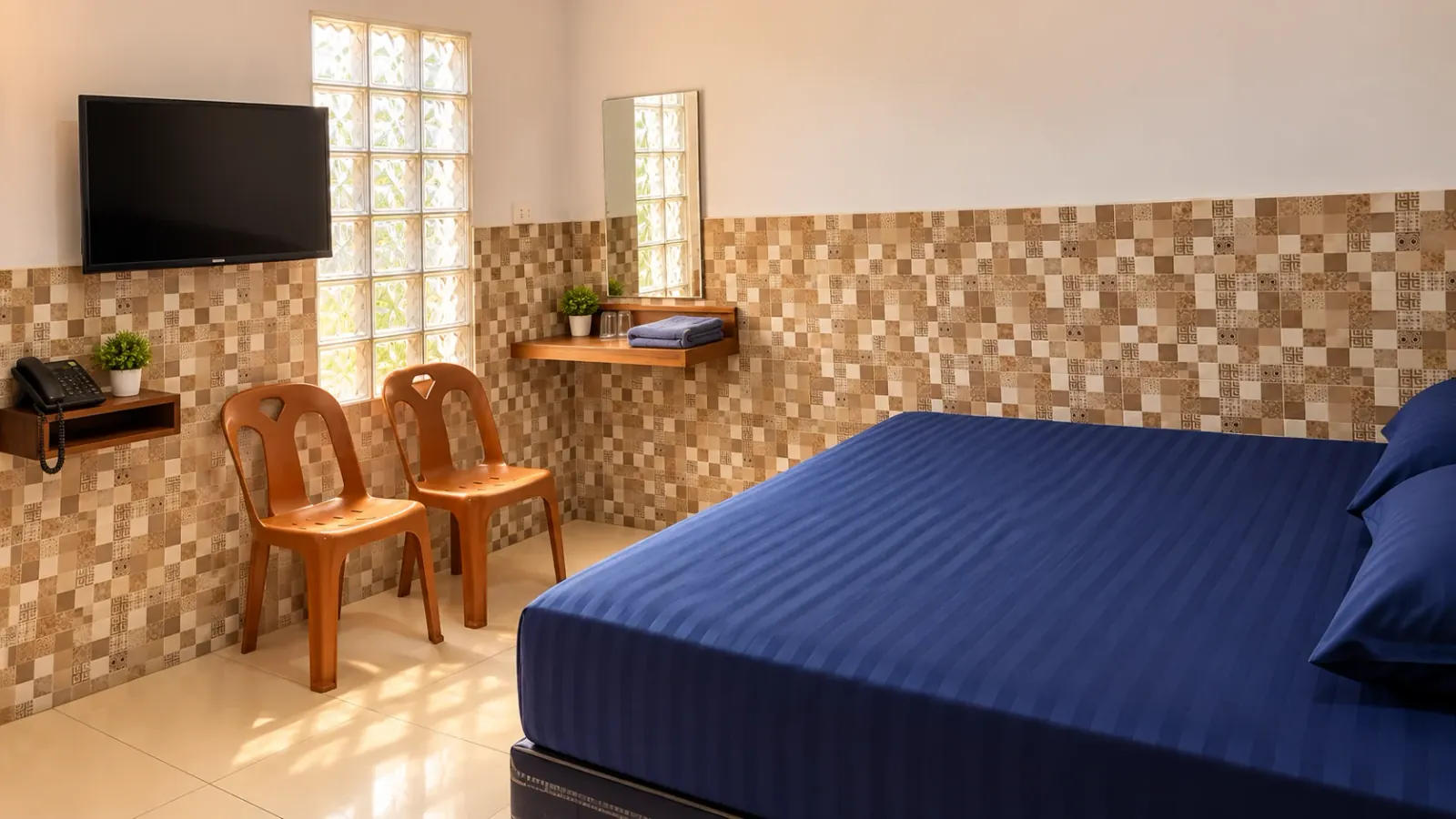 Kamar AC Penginapan Angkasa dengan meja rias dan kursi